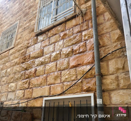 קיר אבן עם חלונות סגורים וסורגים